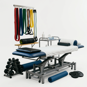 Physical therapy treatment table with exercise bands, dumbbells, and a therapist attending a patient in the background